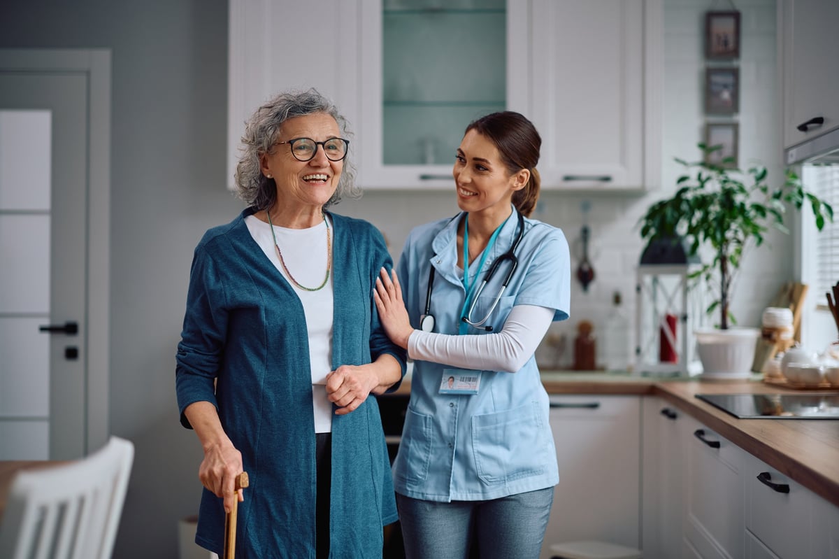 Caregiver assisting resident in home kitchen