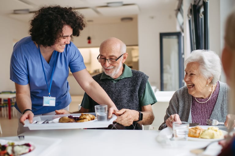 Elderly residents enjoying delicious meal together